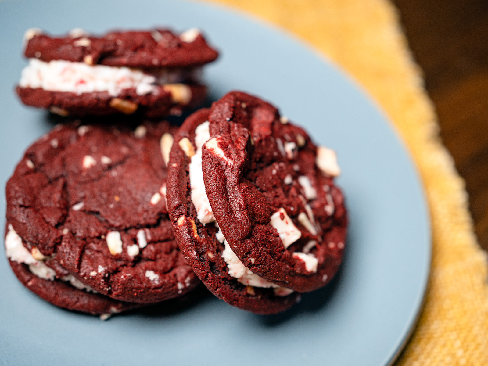 red velvet and peppermint cookie sandwich on blue plate