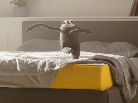 eve sleep sloth mascot dancing on an eve sleep mattress