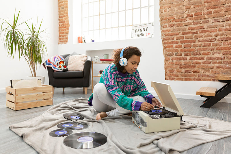 Woman listening to records through a bluetooth adapter for stereo