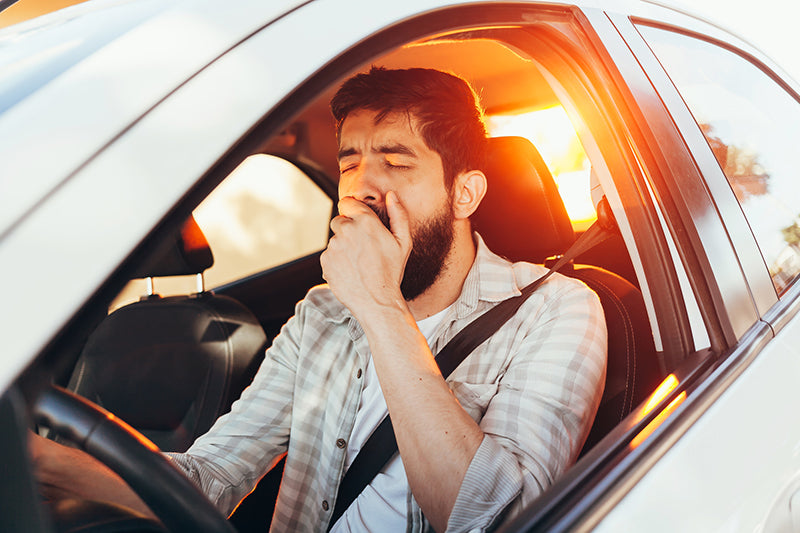 Man in car yawing before being able to use his bluetooth receiver to listen to music