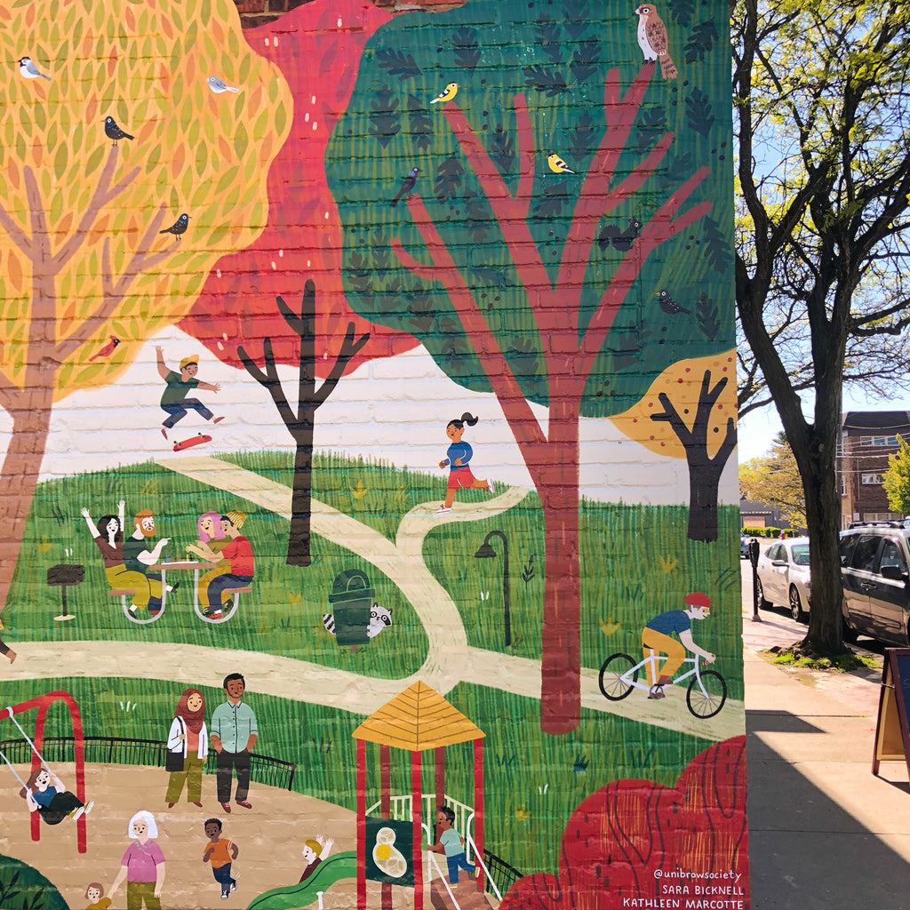 Section of mural with trees, children on a playground, a biker, a runner, a skateboarder, and a group of friends at a picnic table playing a board game