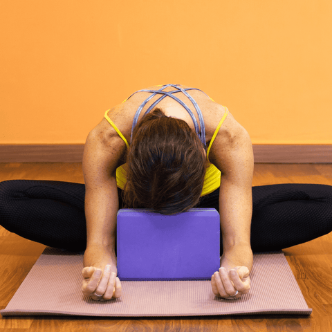 woman in a yin pose on a yoga mat