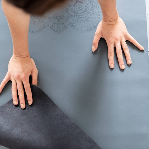 woman using a grey yoga mat