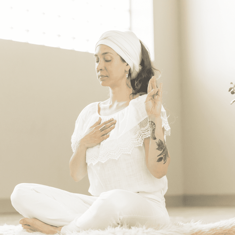 woman dressed in white meditating