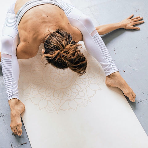 woman in a yin yoga pose on a white yoga mat