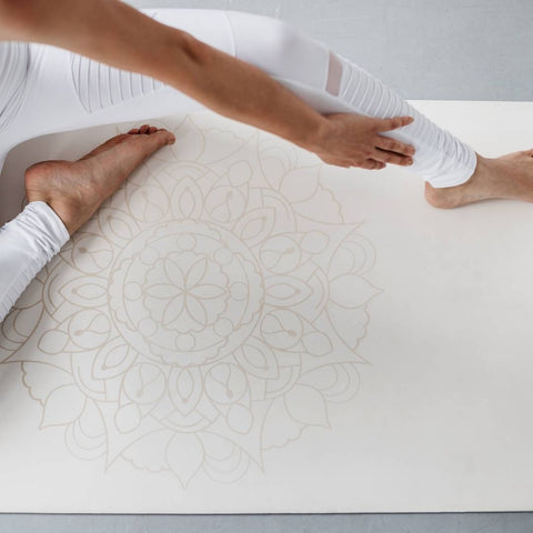 person stretching on a white yoga mat