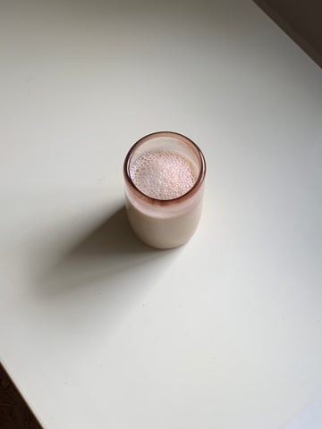 Latte in a pink glass set on a white table