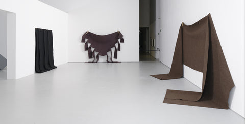 An exhibition gallery featuring three felt works of Robert Morris