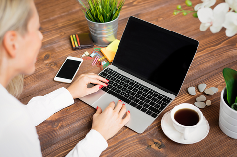 Stylish-woman-sitting-at-her-desk-working-on-a-new-MacBook