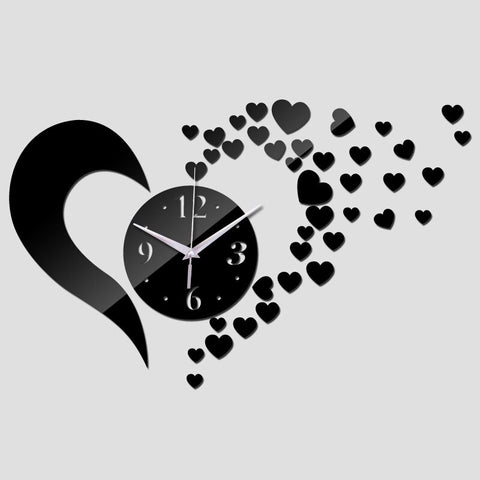 A black flying heart clock. The clock is in the shape of a love heart, with a dial in the centre. The right hand side of the clock looks like it is shattered into lots of tiny little black hearts flying away across the wall.