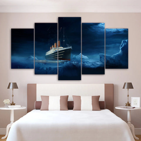 A five piece canvas set which features an image of Titanic. The canvas set is hung up on the wall of a bedroom with a bed underneath the canvas.