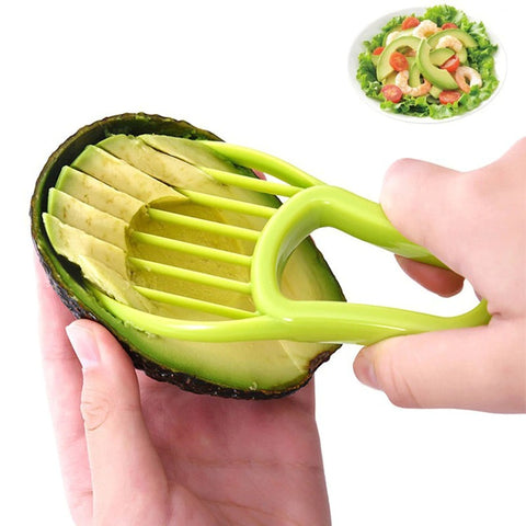 A pair of hands using a green 3 in 1 avocado tool to remove flesh from half an avocado