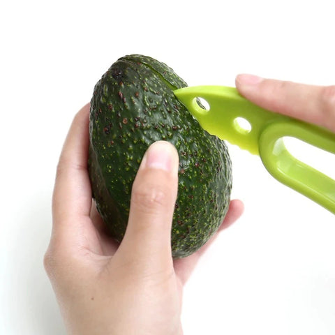 A pair of hands using an avocado tool to piece the outer skin of an avocado preparing to cut it open