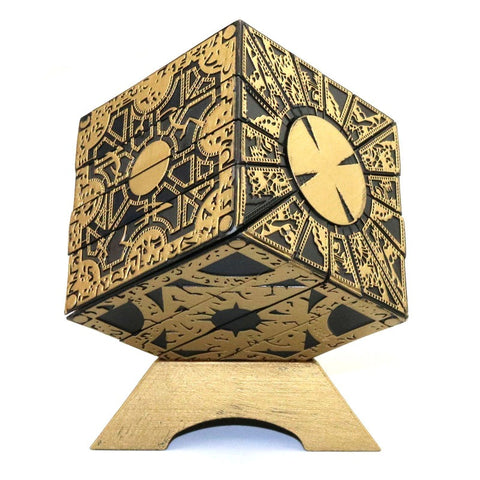 A figurine of the puzzle box from Hellraiser complete with a golden stand.