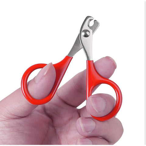 A pair of red and silver cat claw clippers in a persons hand