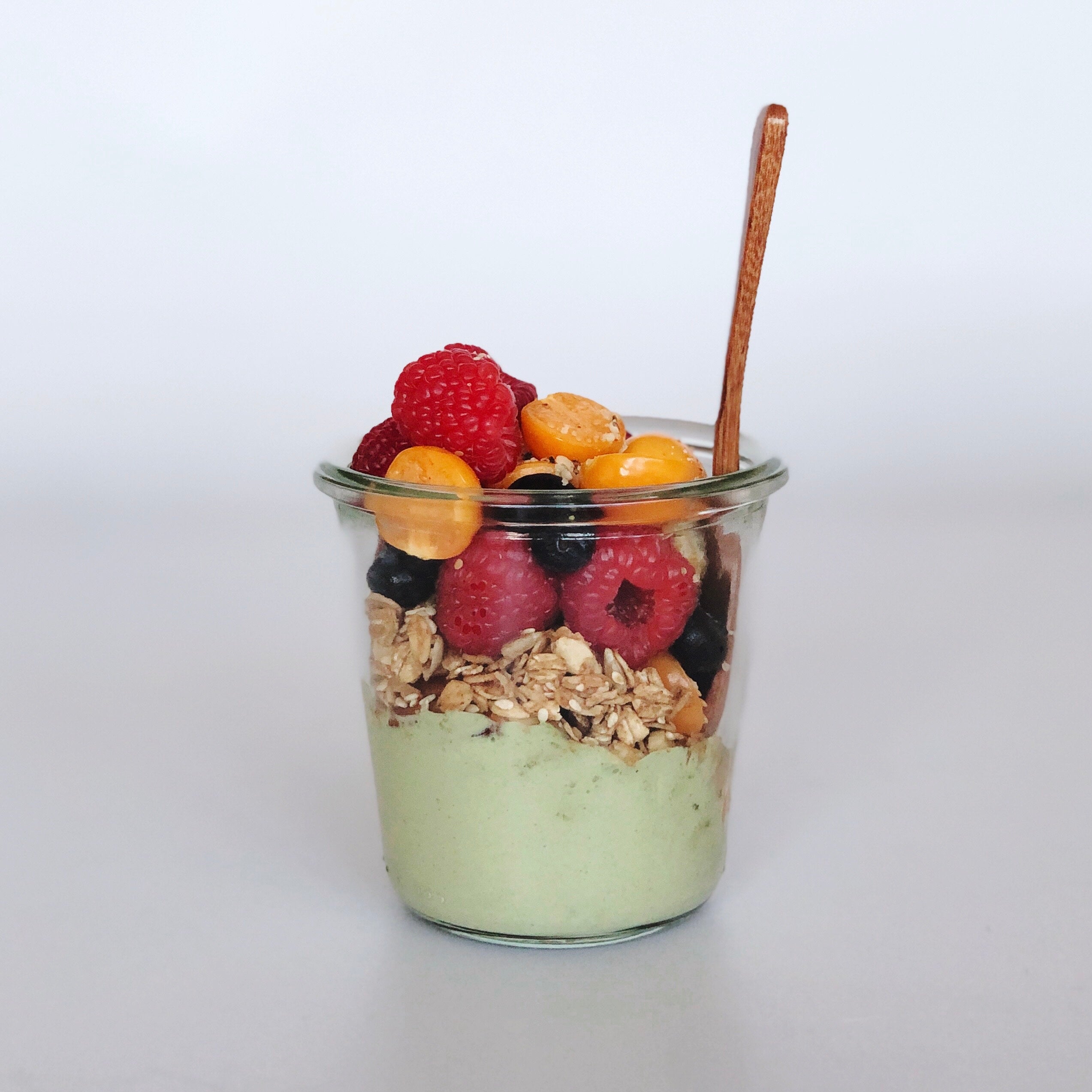 Cup of matcha yogurt with granola and fruit