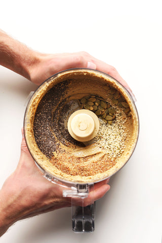 two male hands holding a kitchen mixer filled with sunflower seed butter