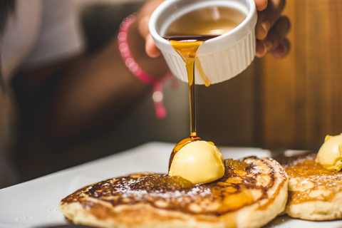 Maple syrup being drizzled over pancakes