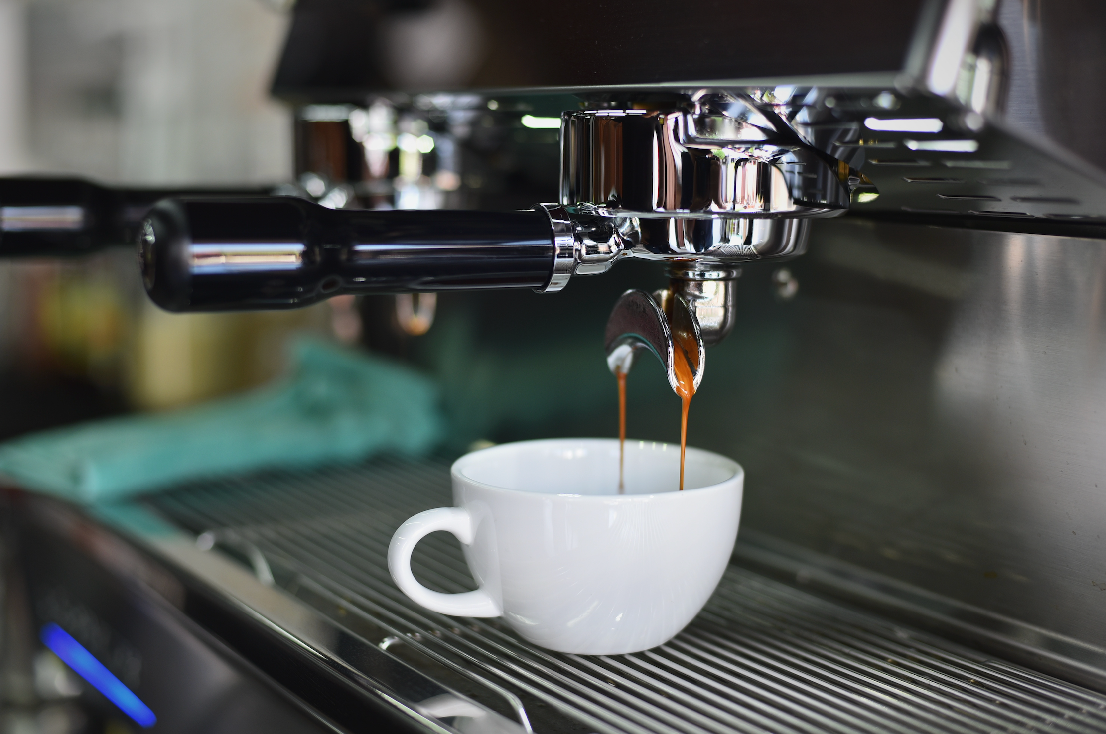 Espresso shot dripping into a capuccino cup 