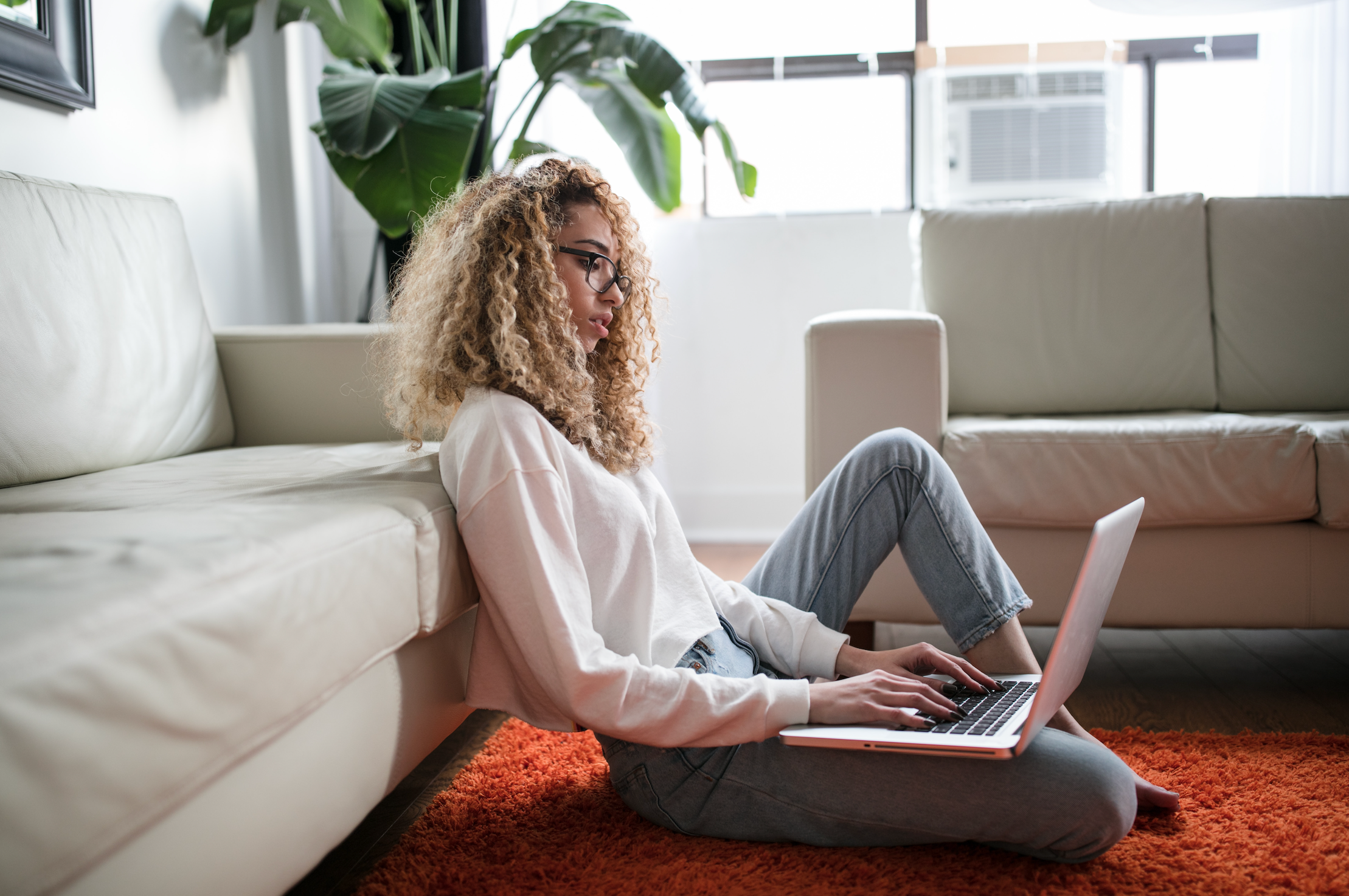 Woman with curly hair working on her laptop