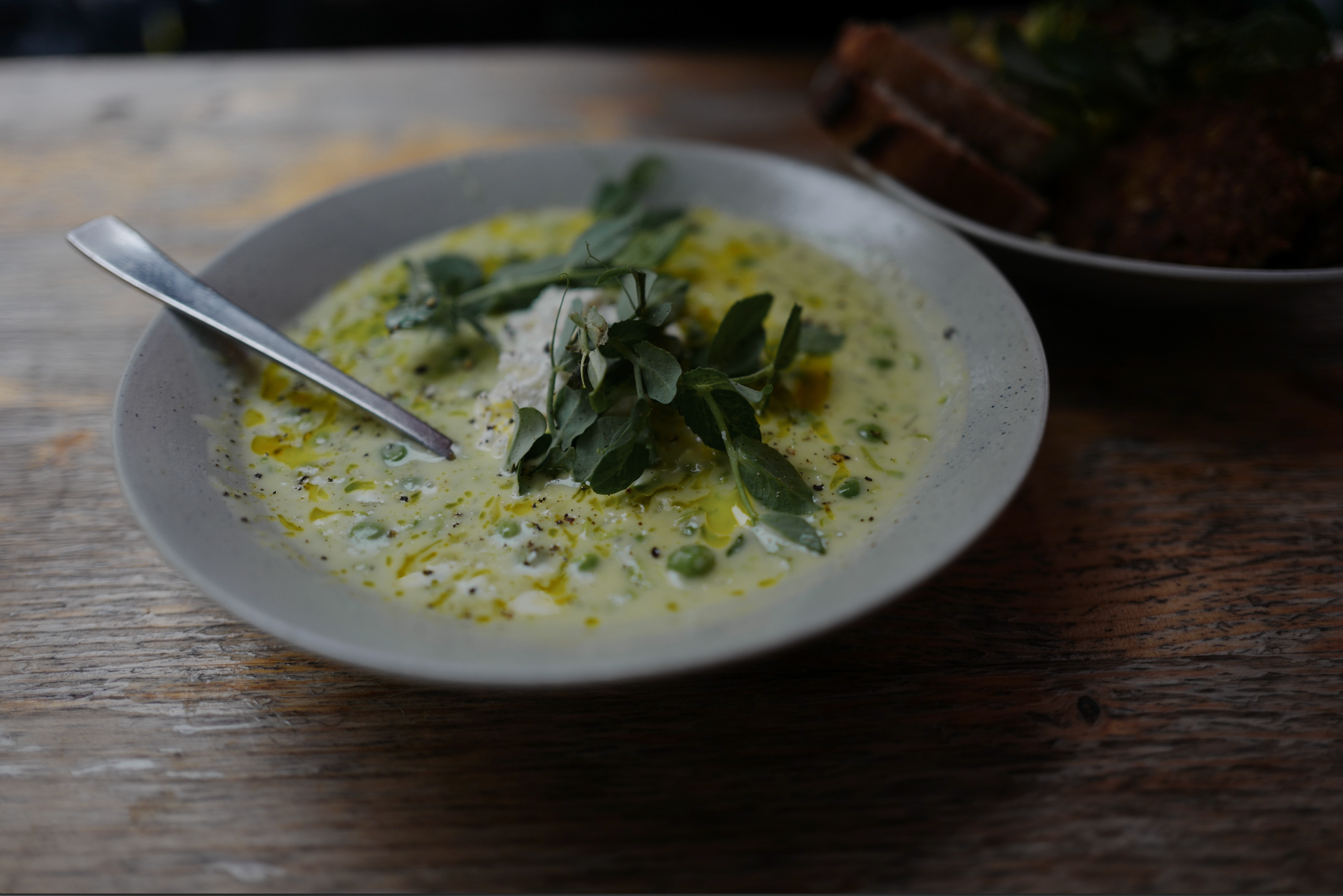 Image of green soup with green leafy garnish