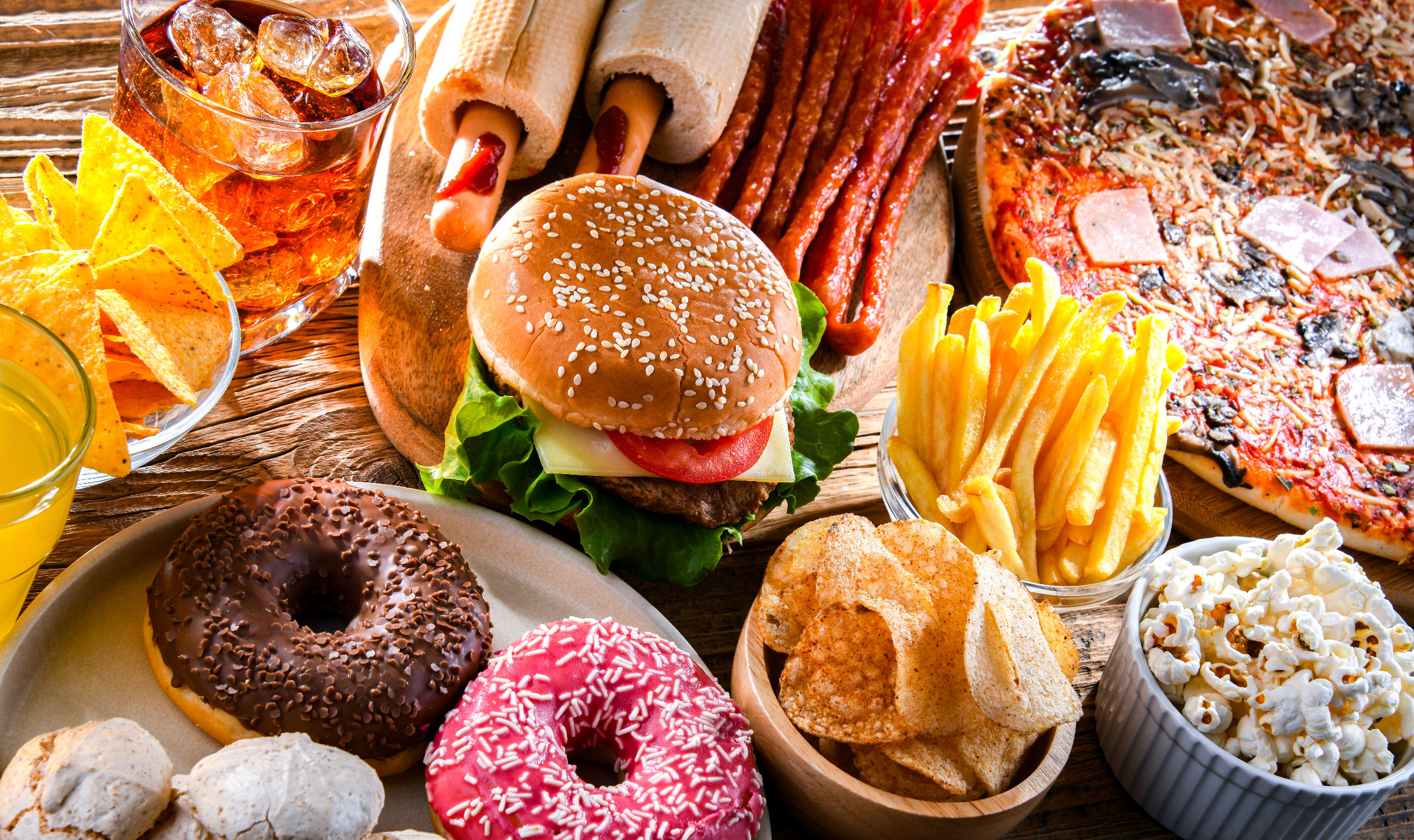 An array of various junk foods like donuts, burgers, chips and pop