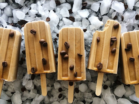 coffee popsicles on ice background with beans on top