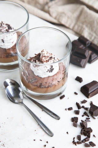 vegan espresso mousse in a glass with chopped chocolate and two spoons