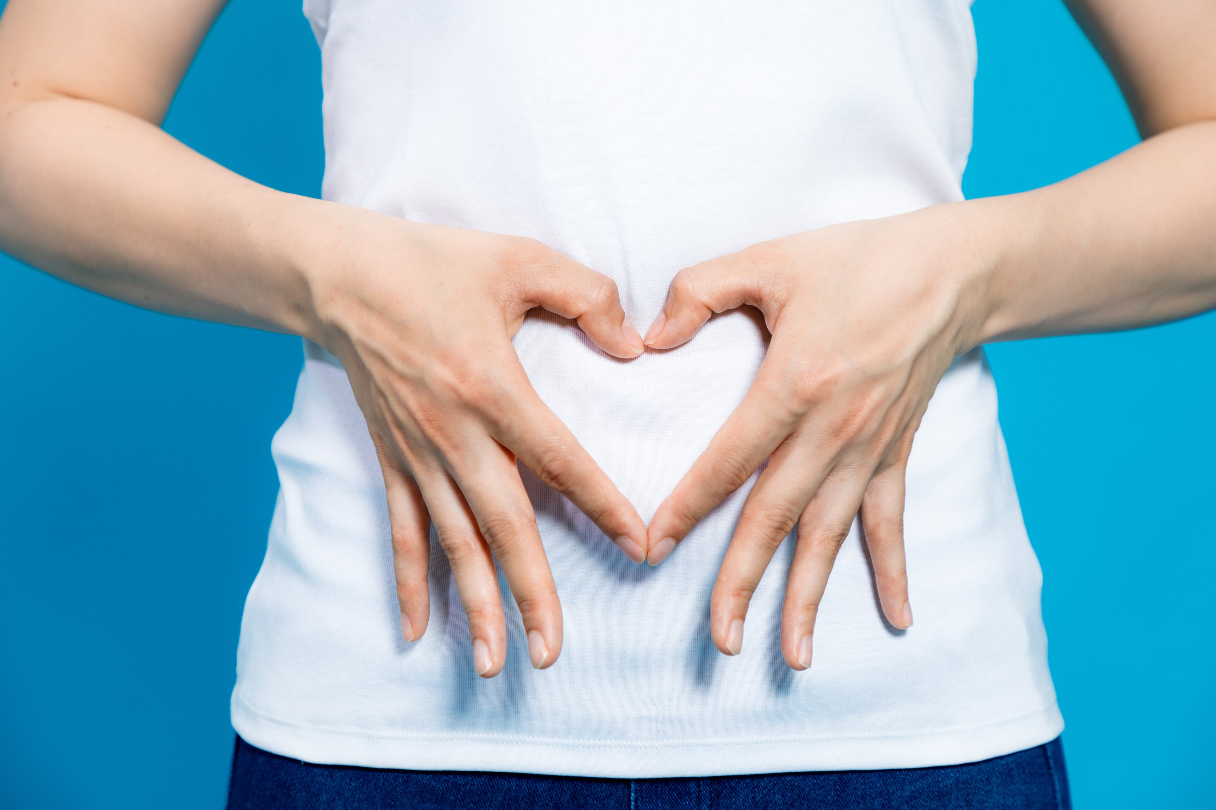 Hands forming heart on stomach