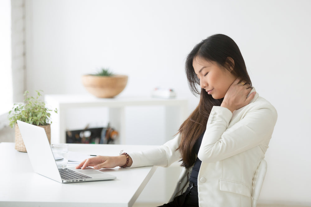 Young woman holding neck in pain