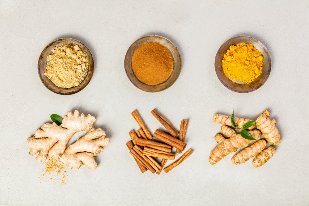 Overhead image of whole and powdered Turmeric, Ginger and Cinnamon