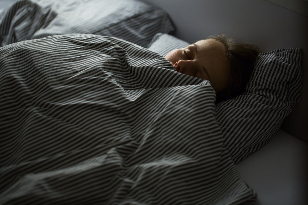 Woman sleeping in striped bedding