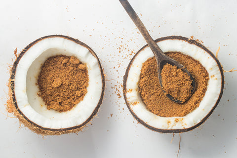 Overhead shot of two coconuts filled with coconut sugar