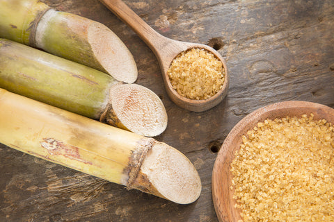 Spoonful of cane sugar with sugar cane