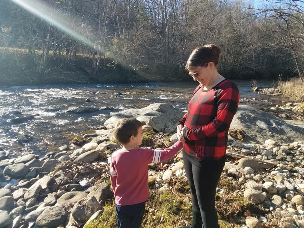 pregnant mom with her son by a river