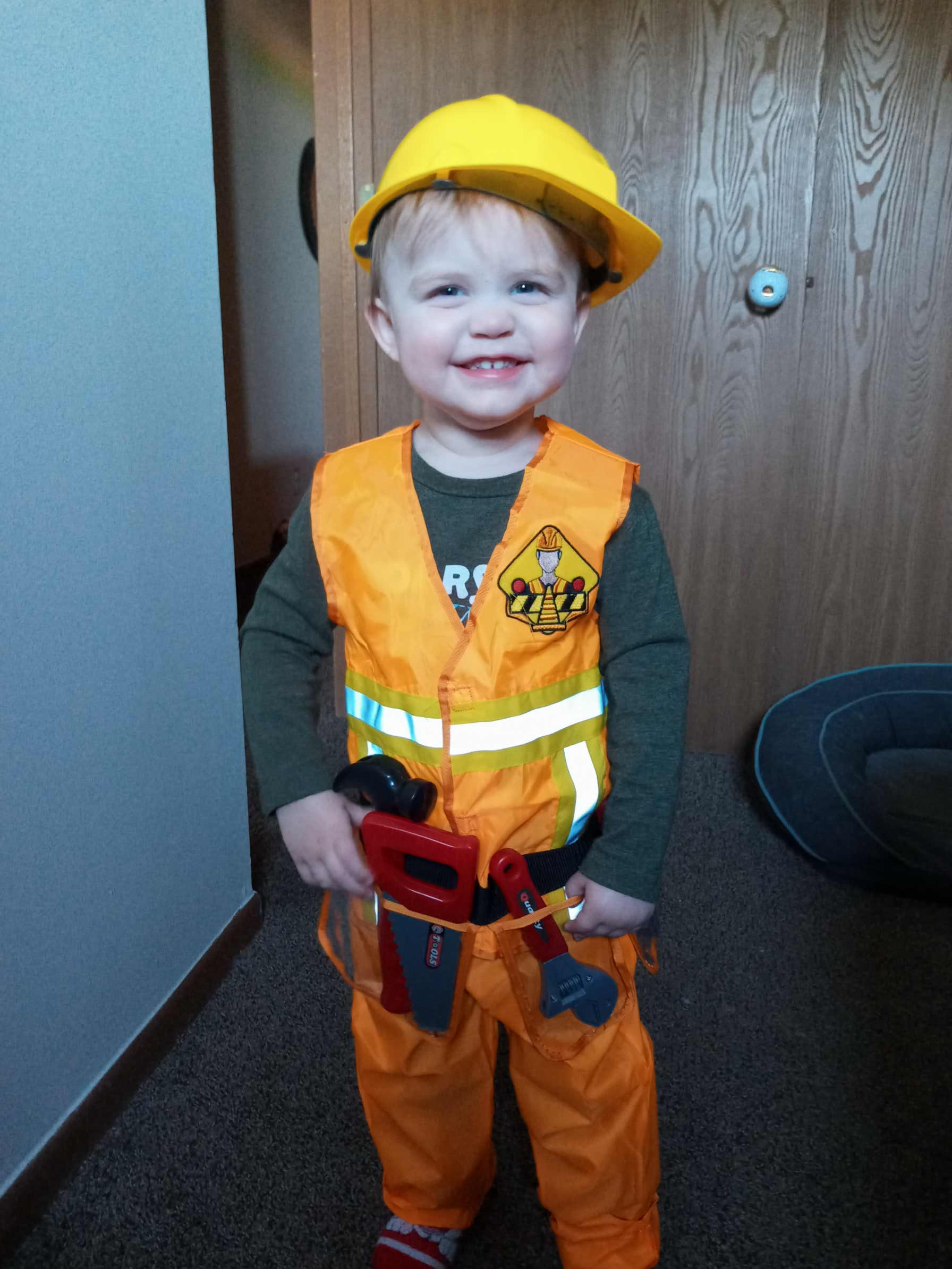 Mosie Baby toddler proudly smiles in construction worker costume