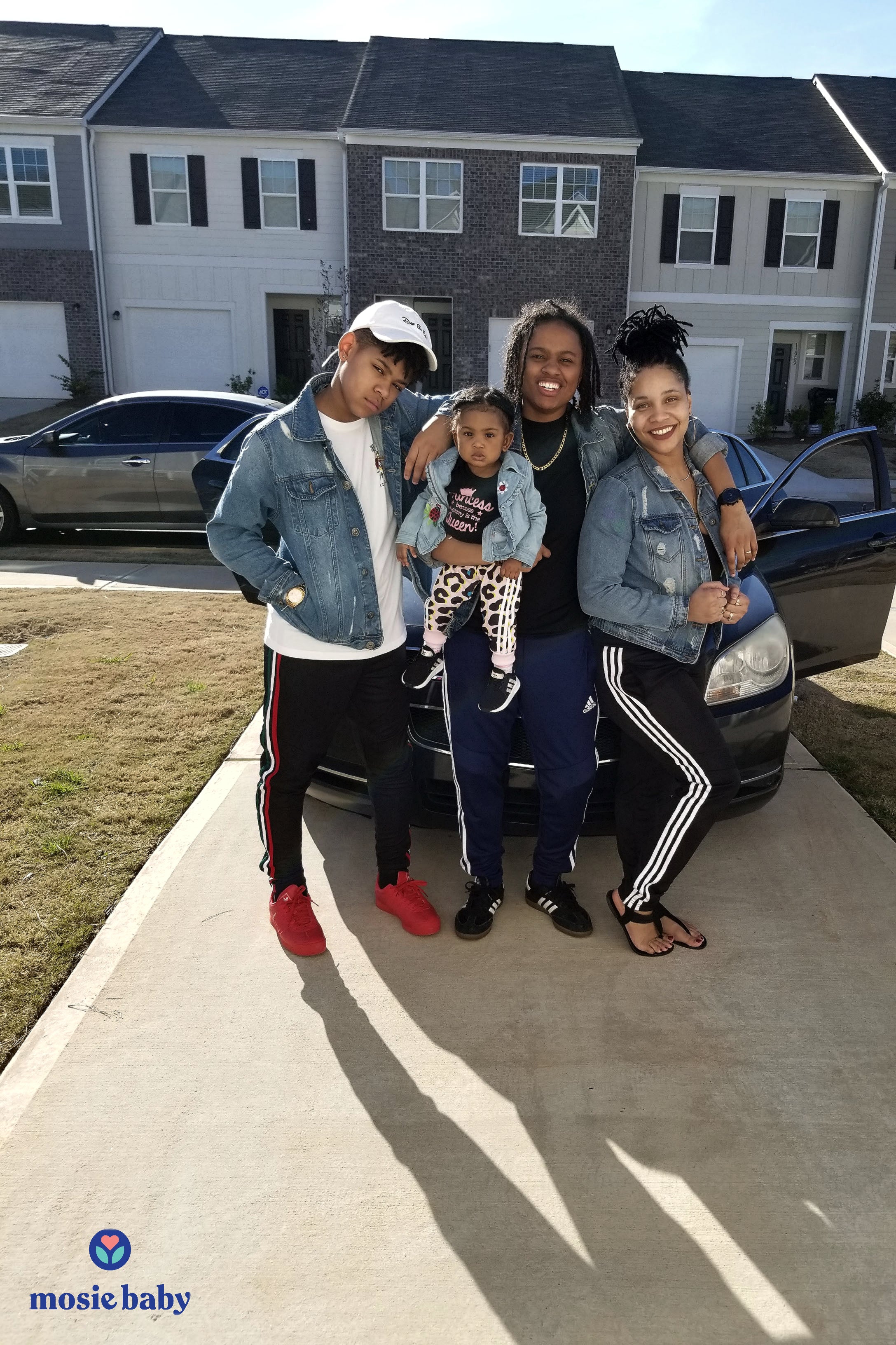 Mosie Baby Family standing in front of their house