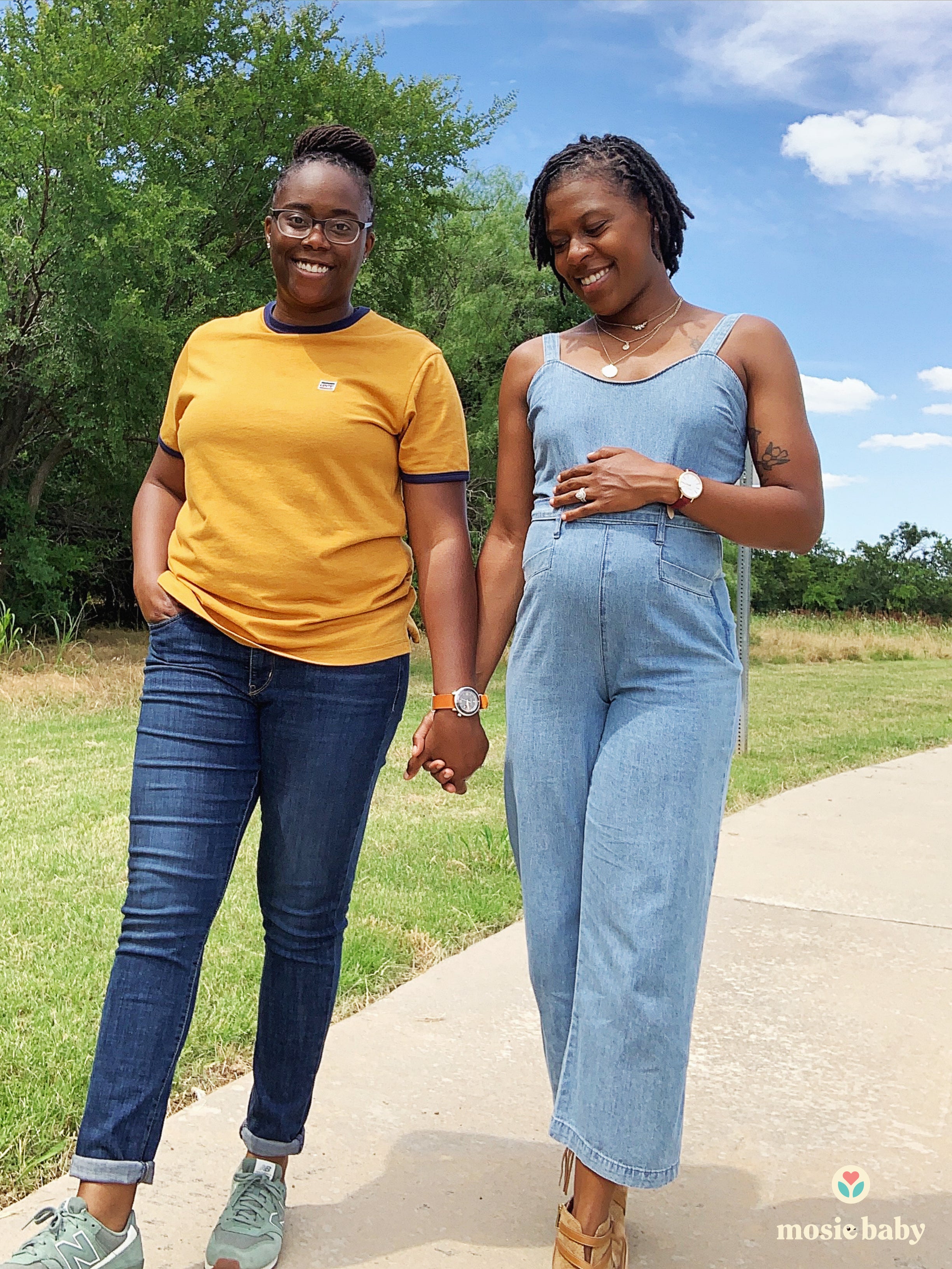 Pregnant Lesbian couple holding hands on a walk 