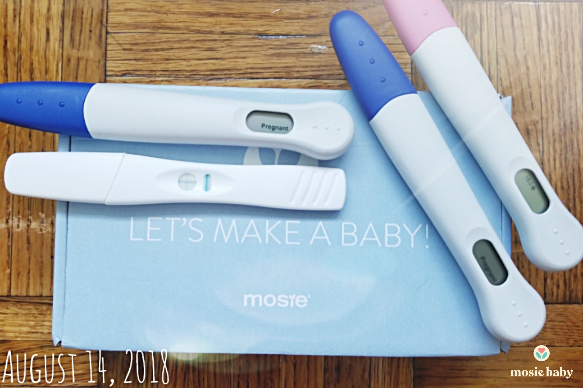 positive pregnancy tests on top of a mosie baby box