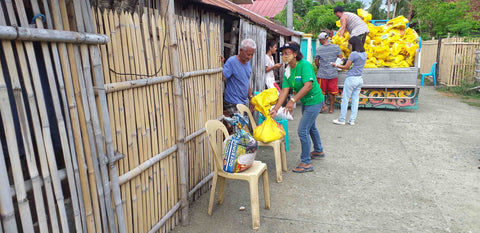 Families holding signs saying thank you for the rice distribution!