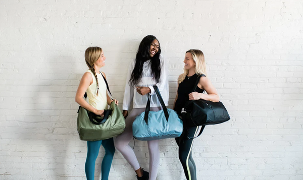 Three women showing off their athletic bags