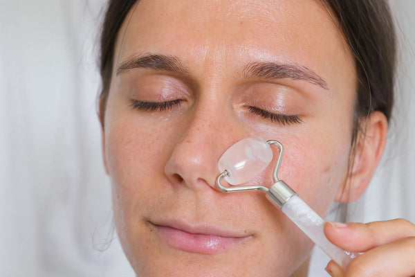adi arezzini using the clear quartz facial roller for increased blood flow