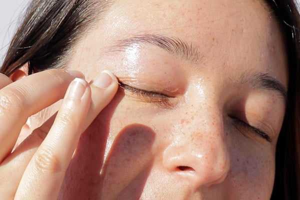woman applying hibiscus infused-eye cream under her eye