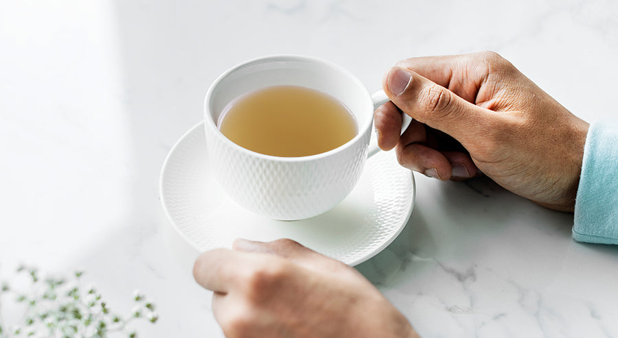 Person Holding a Cup of Lemongrass Tea