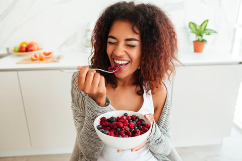 Woman eating healthy berries happy