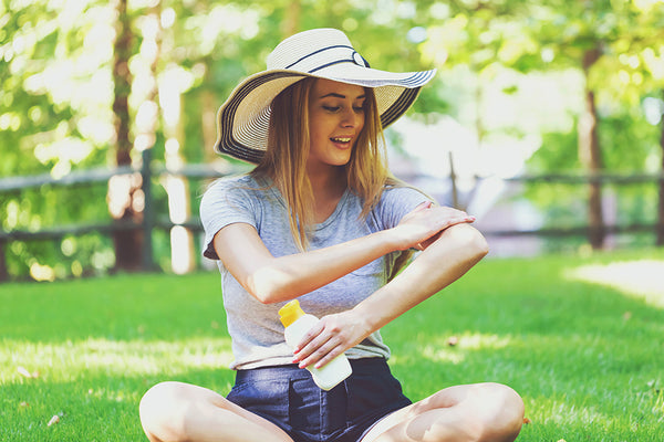 woman applying sunscreen to protect herself from the sun