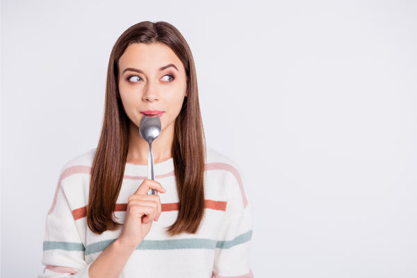 woman with spoon looking hungry