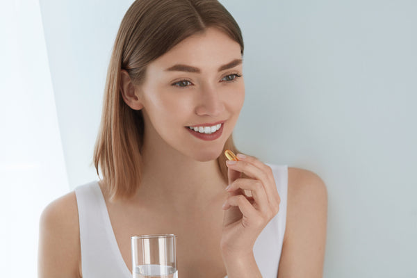 young woman taking a vitamin
