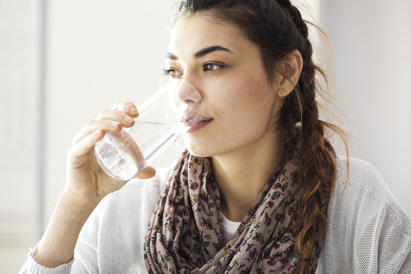 woman drinking water to cut on caffeine
