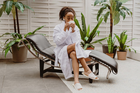 Woman sitting and relaxing enjoying a cup of tea in a bath robe